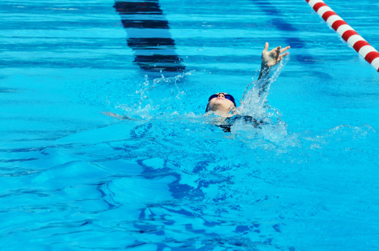 Young Boy Male Athlete Backstroke Swimming Racing in Pool