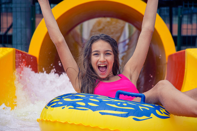 Girl going down water slide on a tube