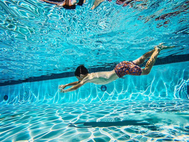 kid swimming under water pool