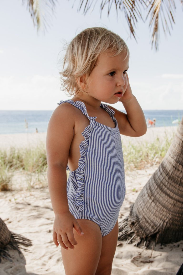 little girl in striped one piece swimsuit