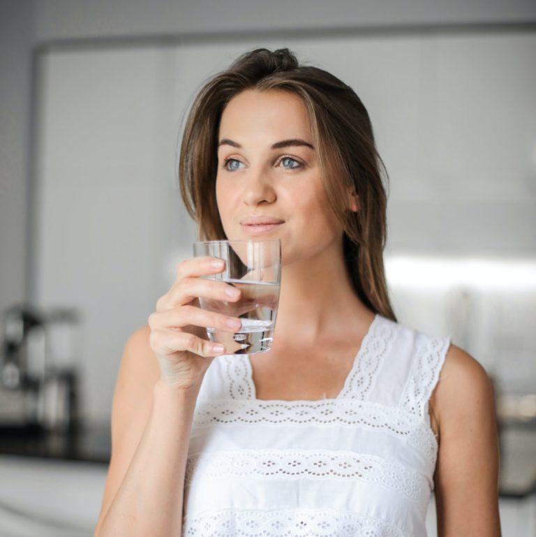 lady in white shirt drinking water