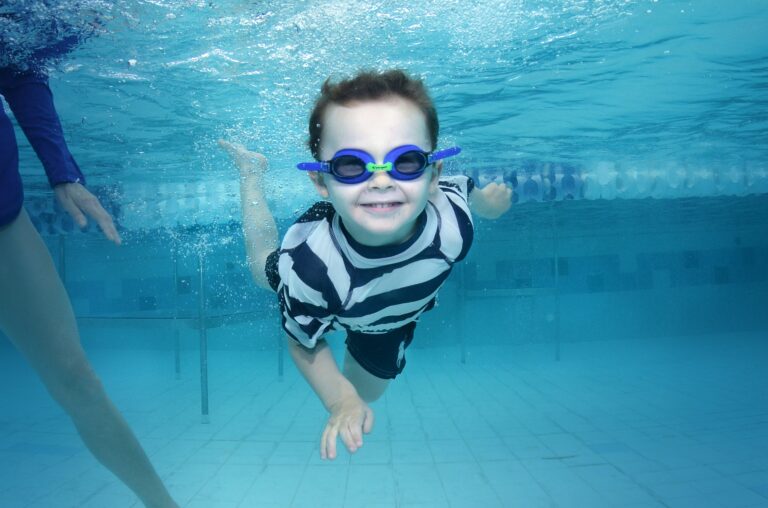 child smiling swimming under water